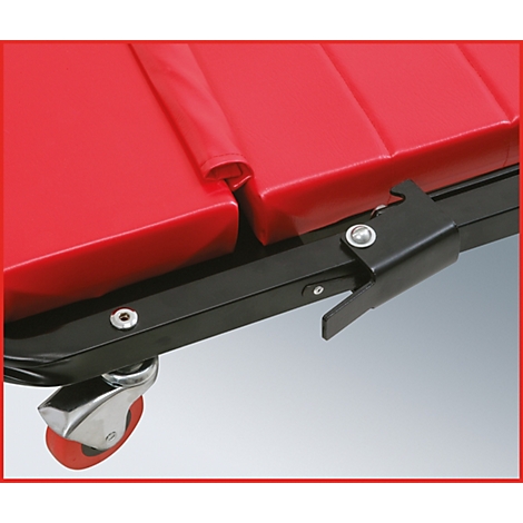 Gros plan d'un tabouret de mécanicien rouge. Détails : siège rembourré, cadre métallique, roues et fermeture noire.